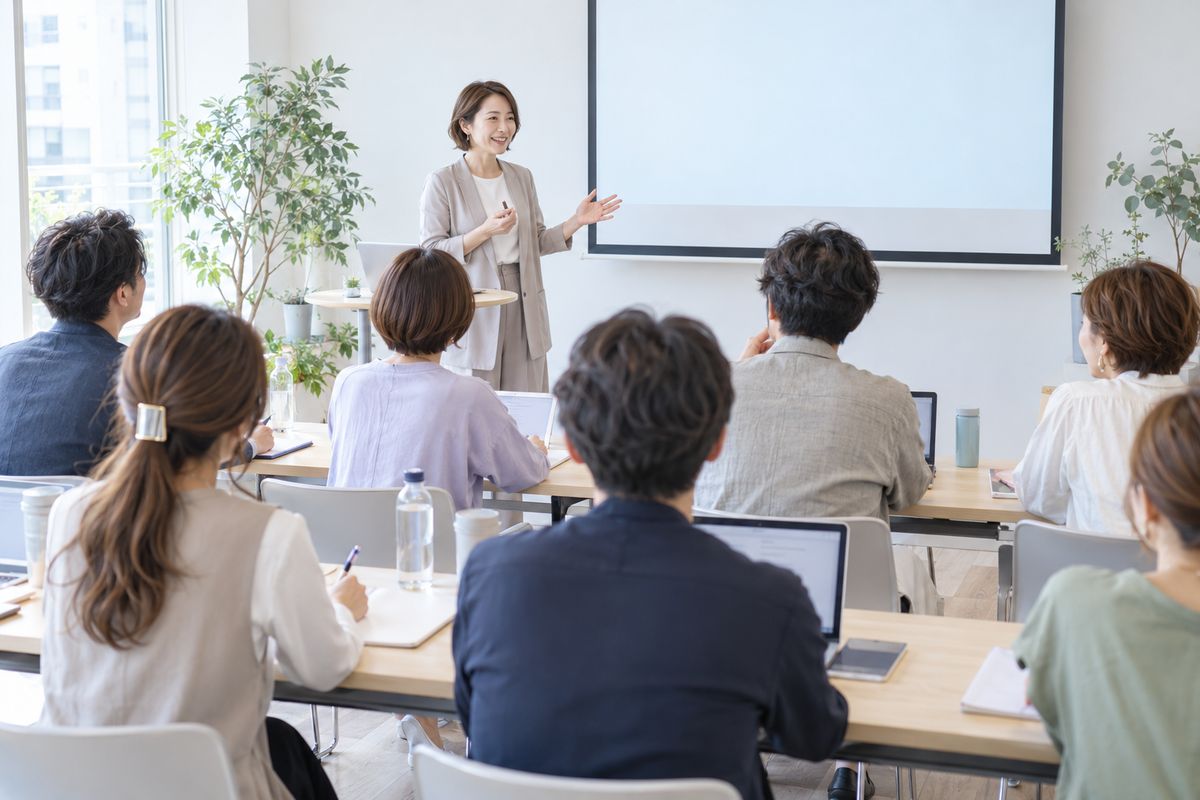 少人数の研修で、講師の話を聞きながらサロン経営者がメモを取るイメージ